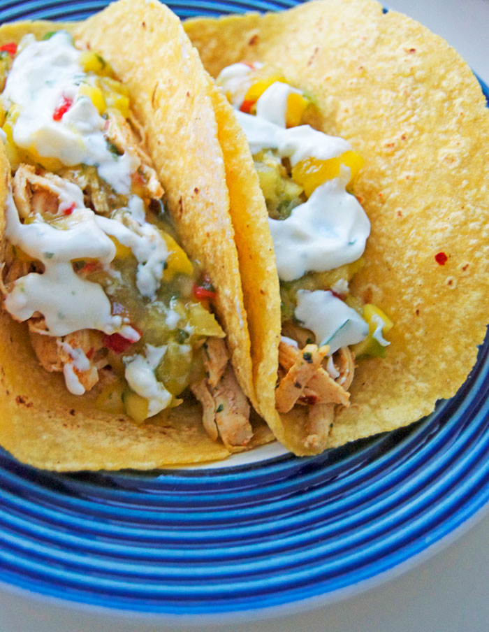 Let's taco about this dy-na-mite combo in time for Cinco De Mayo!! Pulled chicken tacos topped with pineapple mango salsa + lime crema | dcgirlinpearls.com