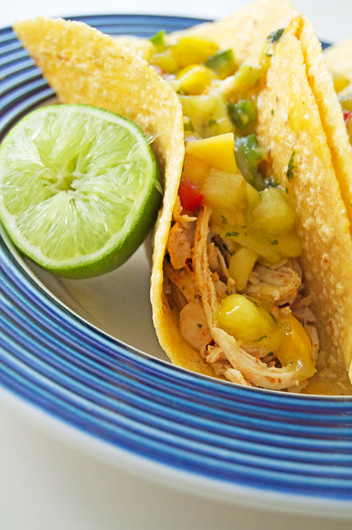 Let's taco about this dy-na-mite combo in time for Cinco De Mayo!! Pulled chicken tacos topped with pineapple mango salsa + lime crema | dcgirlinpearls.com